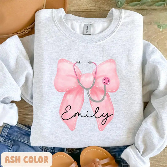 Custom Coquette Name Gift For Nurses, Healthcare Workers Sweatshirt, Pink Bow & Stethoscope Design, Nurse Bow Shirt, Christmas Nurse Gift, Unisex Shirt, Gift For Her